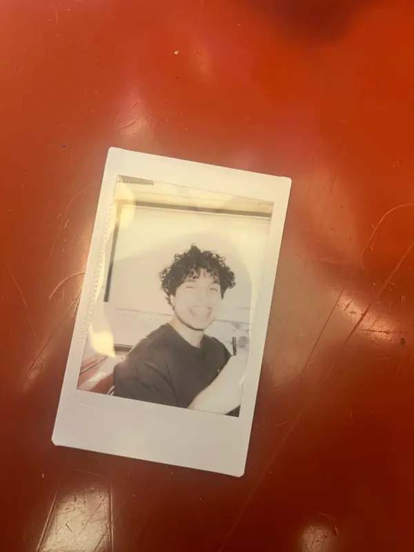 An instant photo of Shriram on a red table
